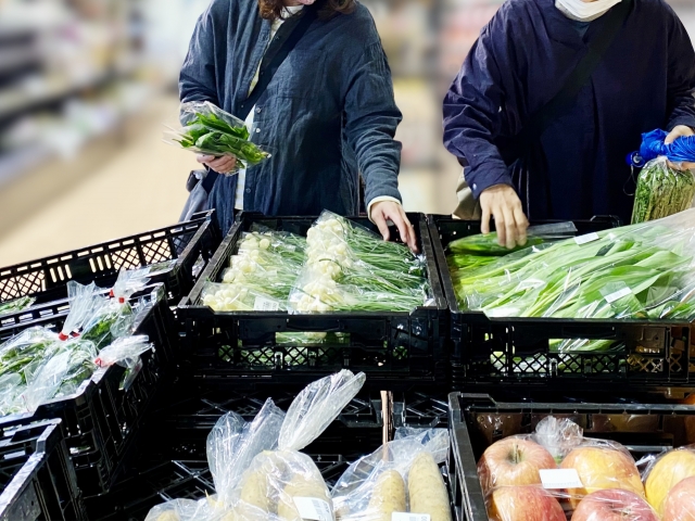 野菜売り場で横に並ぶ女性の手の画像