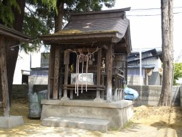 木漏れ日が屋根にあたっている大根2本を描いた絵馬が掛けられているお堂の写真