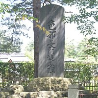 日に照らされた木の影が綺麗に「色部長門君追念碑」という文字が彫られた石碑に当たっている写真