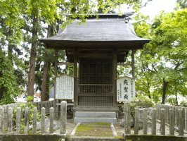 木々に囲まれた柵の中心に縮小生移建された聖堂がある写真