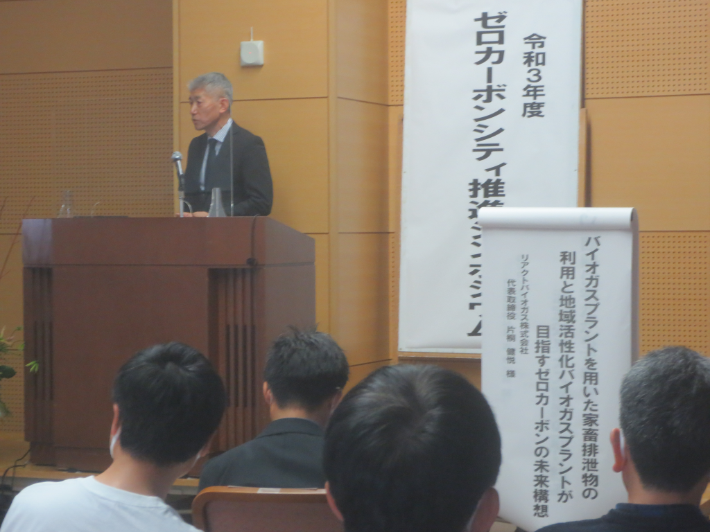 リアクトバイオガス株式会社の男性が演台で話をしている写真