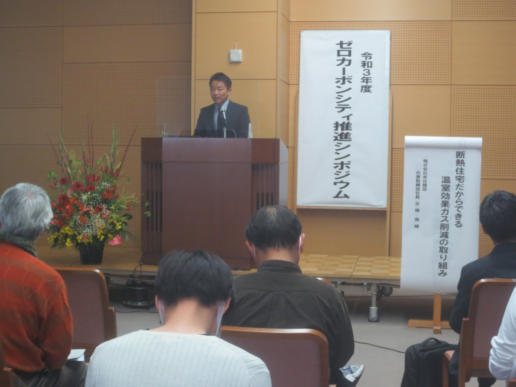 株式会社米住建設の男性が演台で話をしている写真