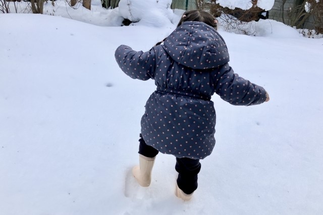 雪に足跡をつけてはしゃぐこどもの画像