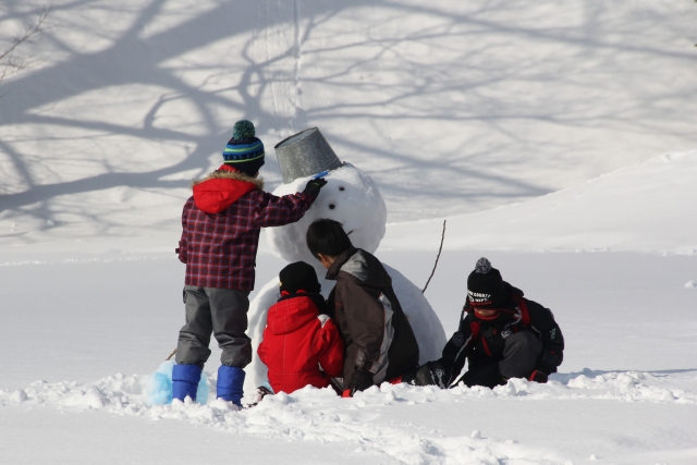 雪だるまをつくる子供たちの画像