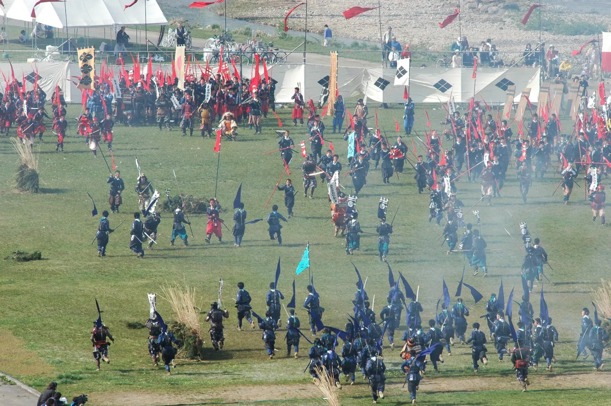 甲冑を着て野原を駆ける人たちの画像