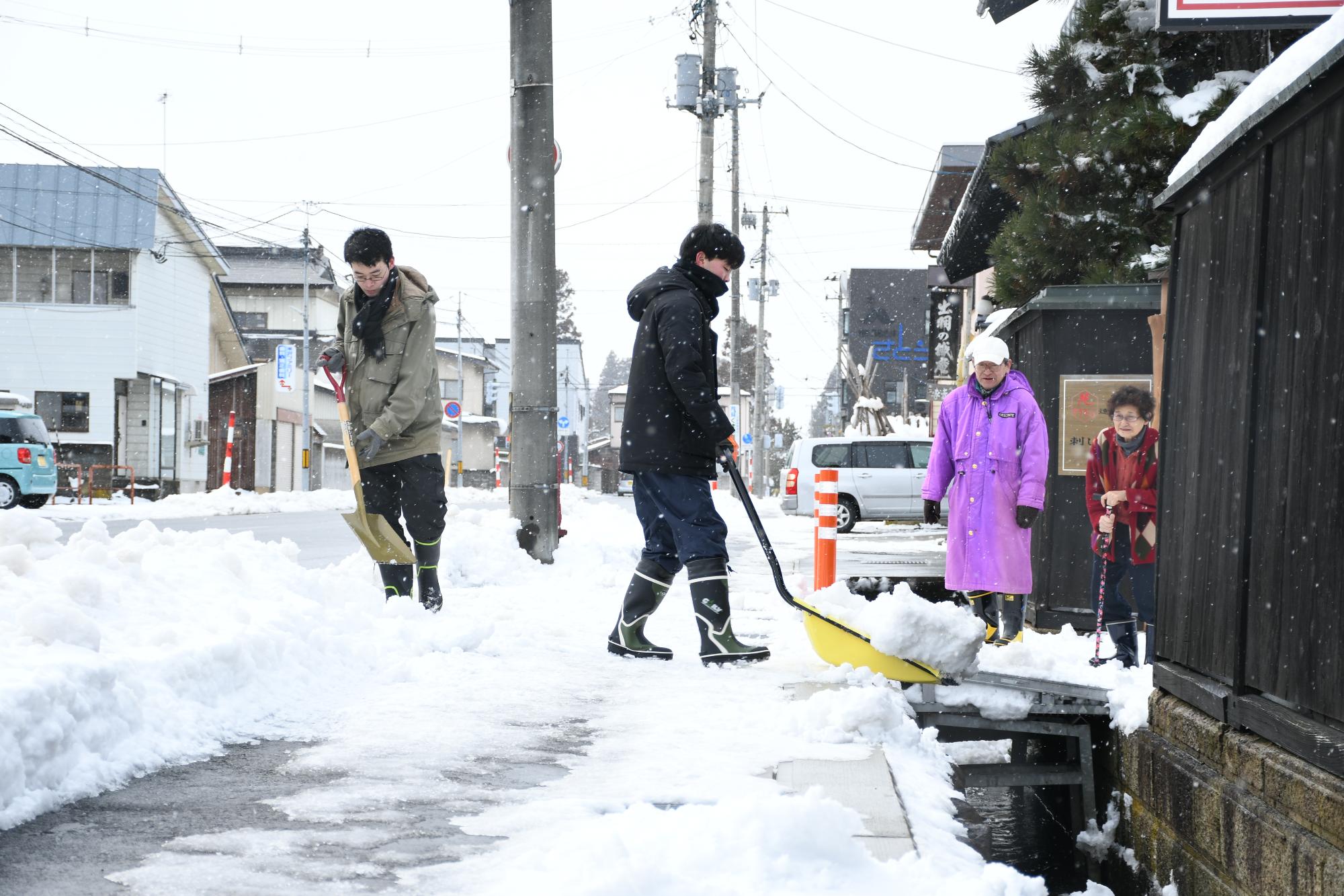 除雪ボランティアをする若者の画像
