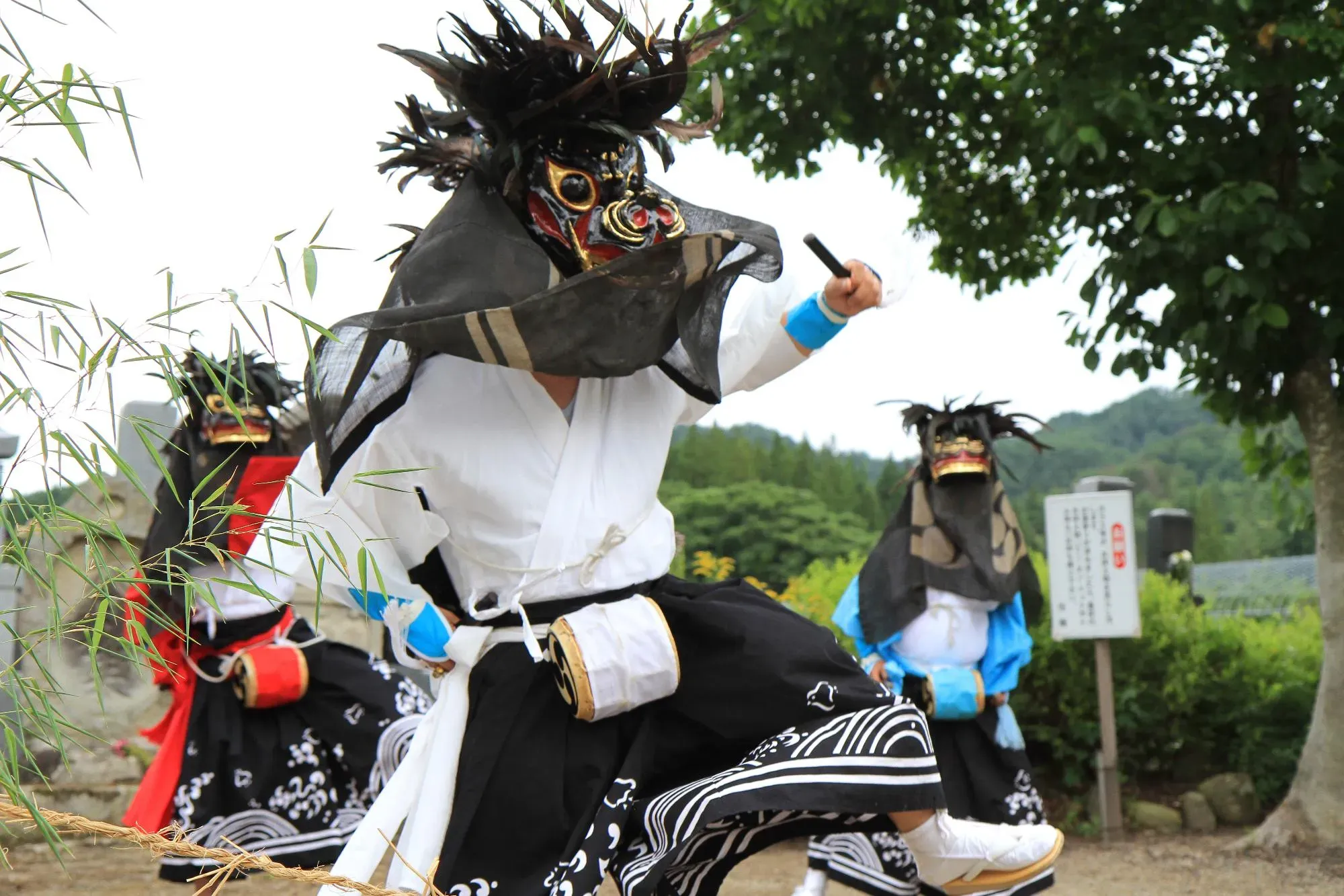 獅子の面を被り踊り舞う人の画像