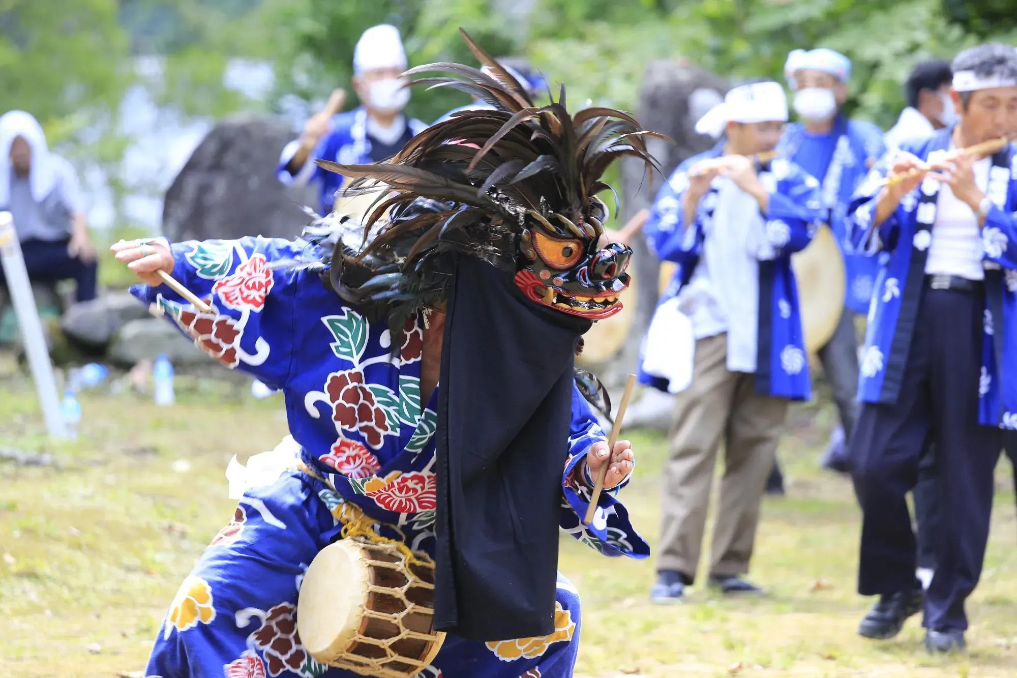 獅子の面を被り踊り舞う人の画像