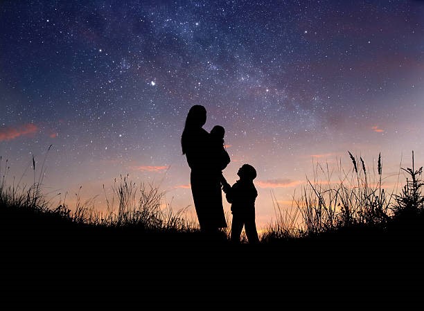 満天の星空の下、母親と子供ふたりのシルエット