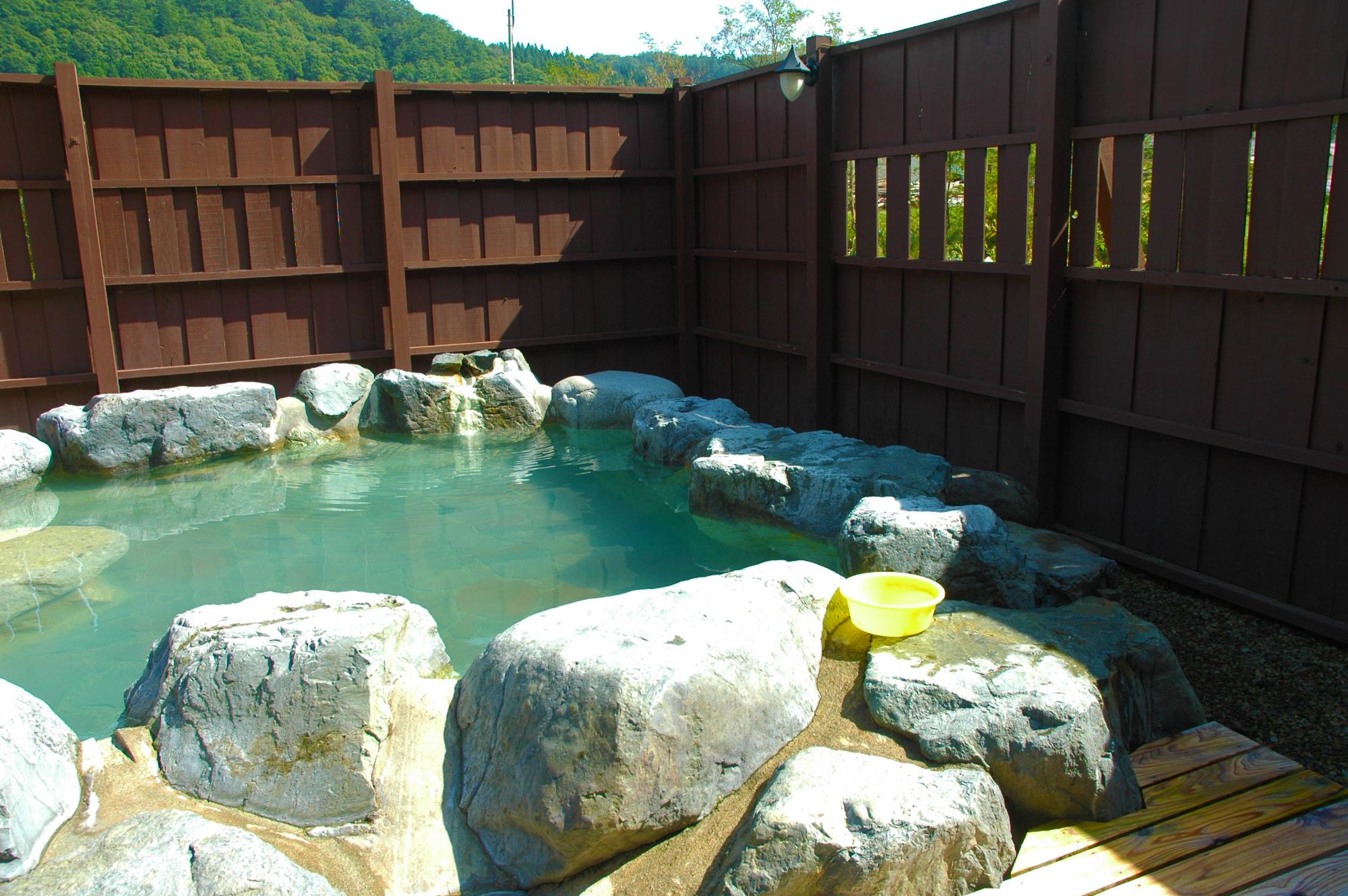 木の塀で囲まれた温泉の画像