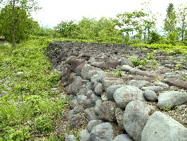 たくさんの大小の河原石が横にならべて積み上げ、造られた石堤の写真