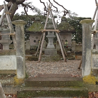 階段を数段上り石門の奥に木材4本で仕立てられた雪囲いの中にある直江兼続公夫妻の墓の写真