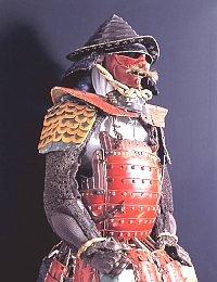兜は笠形、赤塗りの胴と草摺、袖は金色の鱗形、籠手や佩楯は鉄の鎖繋ぎで出来ている前田慶次の甲冑の写真