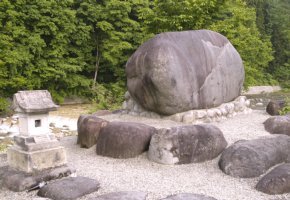 横長の大きい石が並んで一列に置かれその後ろにひときわ大きい石（龍師火帝の碑）が一つある写真