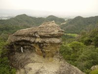 山々や米沢市内を一望できる場所に獅子岩が立っている様子の写真
