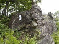 ごつごつした岩に名称が書かれた板のようなものが取り付けられている縁結岩を撮った写真