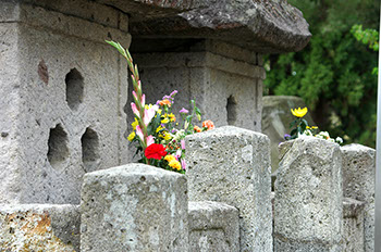 直江家の家紋である 三盛亀甲花菱(みつもりきっこうはなびし)をかたどった六角形の三個の穴があいているお墓の一部の写真