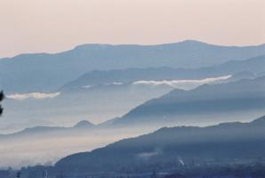 重なる山並みと、山の下には霧のようなものが広がっている様子を撮った風景写真