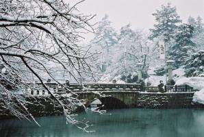 中央に水堀を跨ぐように設置された松が岬公園舞鶴橋の雪景色の写真