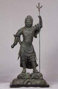 左手は振り上げて戟を持ち、右手は曲げて掌を腰にあてて邪鬼の上に立つ鎌倉時代前期の毘沙門天像の写真