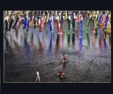 数多くの鯉のぼりが並んで泳いでいる川で、3人の子どもたちが遊んでいる様子の写真