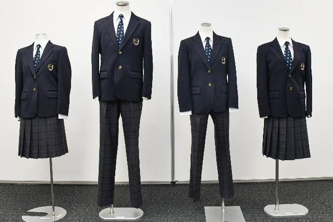 スカートの制服とスラックスの制服が2着ずつマネキン人形に着せた状態で並べられており、スカートやスラックスが薄いチェック柄、ネクタイのドット柄が特徴的な制服の写真