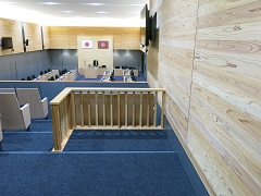 奥に議会席があり、手前に木枠が設置された車椅子用の傍聴スペースがある写真
