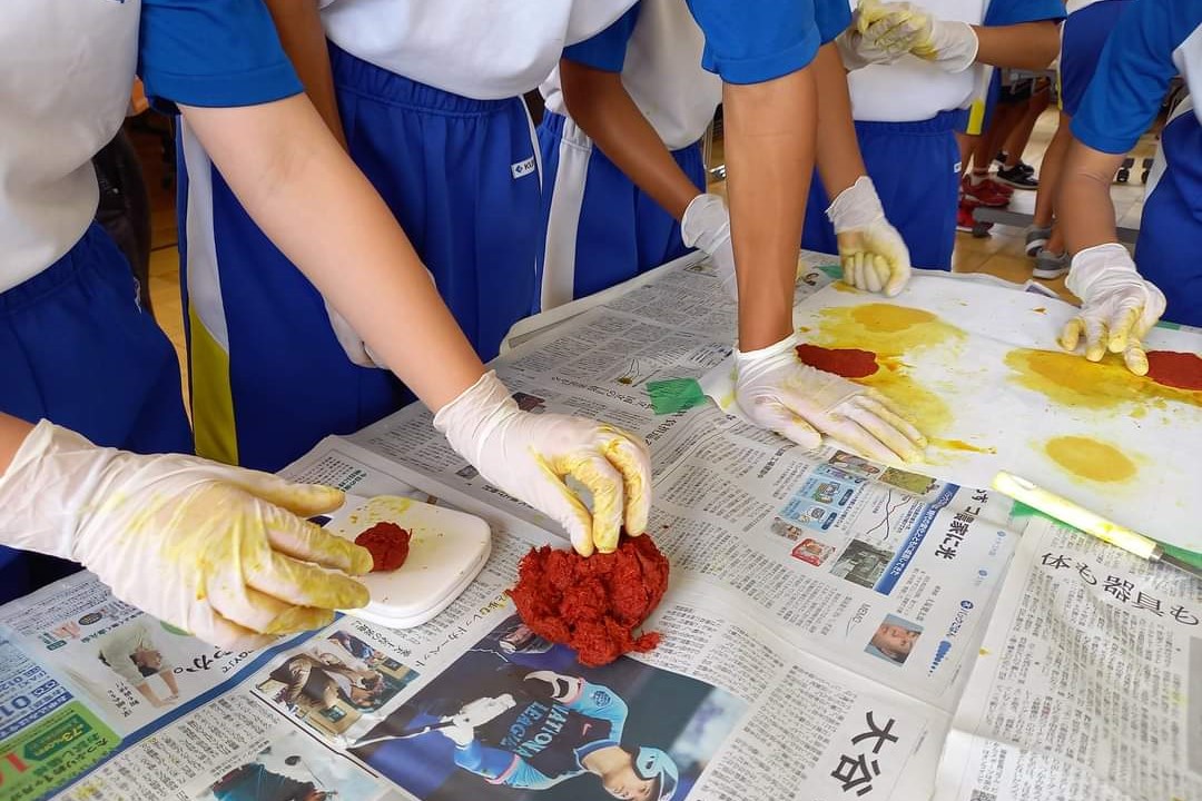 小学生が紅花から紅餅をつくる様子の写真
