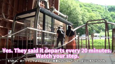 観光客がロープウェイに乗り込もうとしている写真で、ロープウェイの説明が英文と日本語訳のテロップで表記されている写真（YouTube）