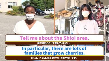 外国人女性と小学生が正面を向いている写真で、塩井地区についての質問と回答が英文と日本語訳がテロップで表記されている写真（YouTube）