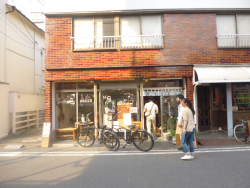 二階建てにレンガの外壁をしたお店に人が入っていく様子を撮った写真