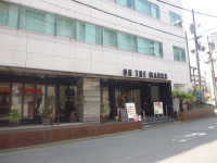 ビルの1階部分がガラス張りになっており、壁に「on the marks」の看板が設置されている外観を道路から撮った写真