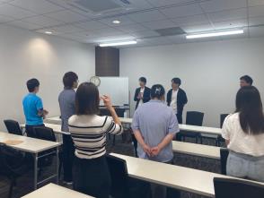 民間交流団体ドットミートの交流会で立ってホワイトボードを見ている様子の写真